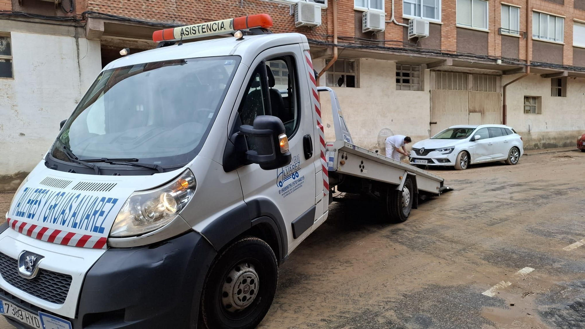 Una grúa se dispone a coger un coche averiado.