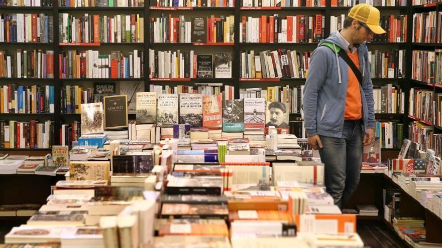 Un hombre observa libros en una librería.