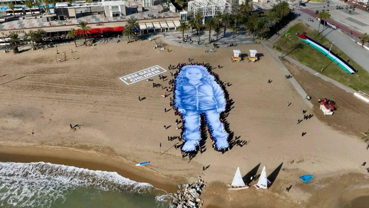 Imagen aérea de la lona de 55 metros de longitud desplegada este jueves en Barcelona, con un retrato de la niña Hind Rajab, asesinada en Gaza por el Ejército israelí 