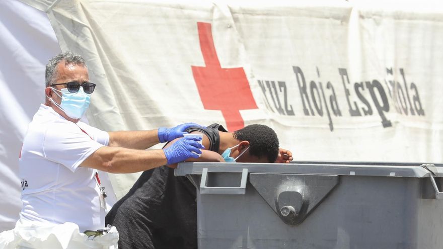 Una de las mujeres rescatadas por Salvamento Marítimo de una patera, llegó al muelle de Arguineguín mareada y con vómitos. En la imagen, es atendida por un voluntario de Cruz Roja.