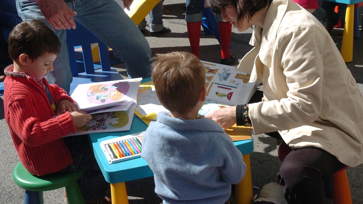 Niños, leyendo junto a una profesora.