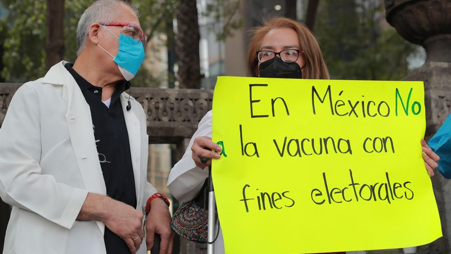 Dos médicos protestan con un cartel que dice "En México no a la vacuna con fines electorales" para exigir la aplicación de la vacuna contra la covid-19, hoy, Ciudad de México (México). EFE/ Carlos Ramírez