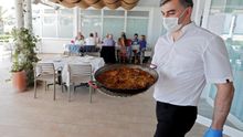 Un camarero sirve una paella en un restaurante de Valencia.