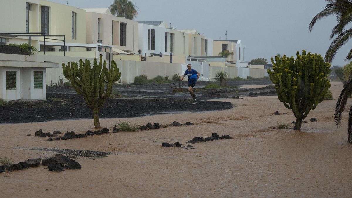 Un hombre corre mientras llueve abundantemente en Teguise, Lanzarote, este sábado.