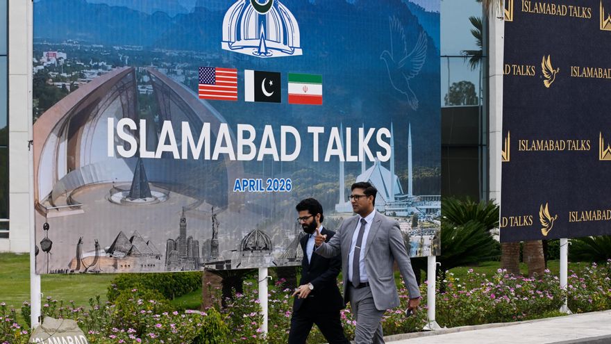 Varias personas pasan frente al centro de prensa para las conversaciones entre Estados Unidos e Irán en Islamabad.
