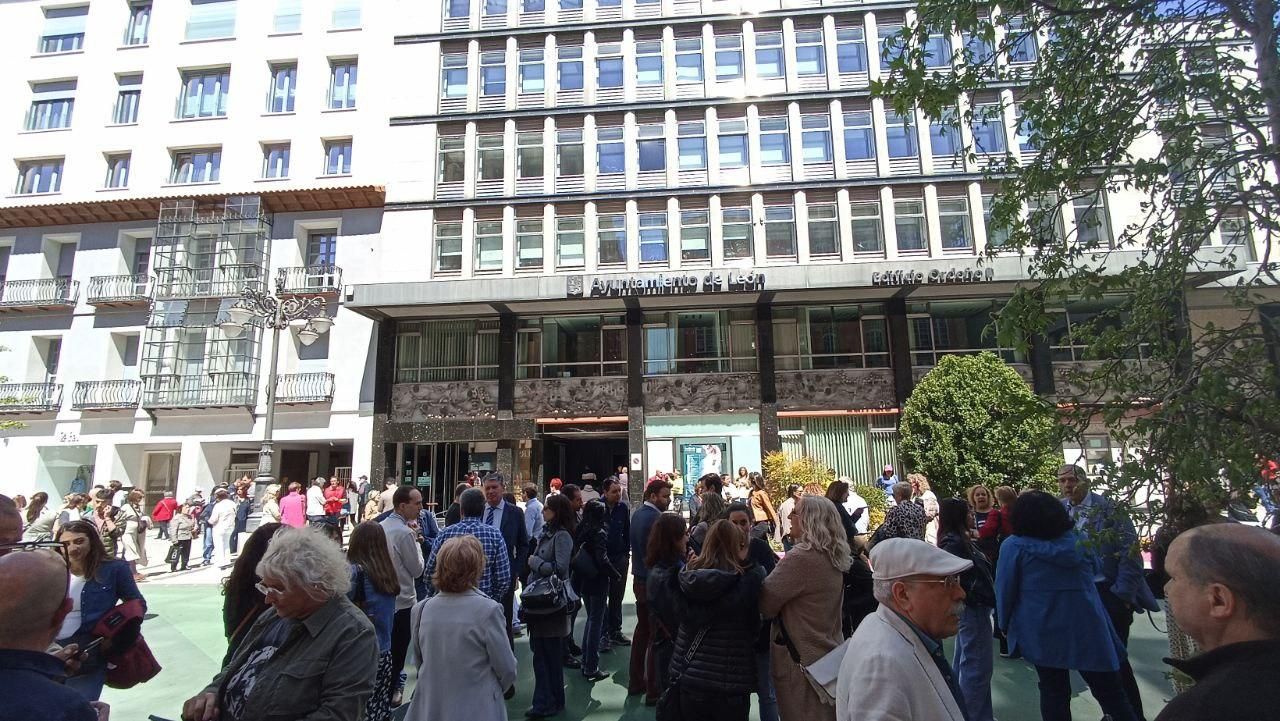 Funcionarios y curiosos se reúnen frente a la sede del Ayuntamiento de León.