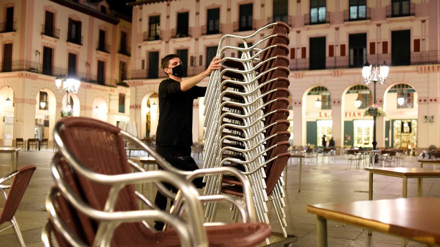 Un hostelero recoge la terraza de su establecimiento de Huesca. EFE/ Javier Blasco/Archivo