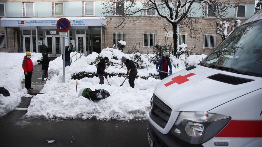 Varios voluntarios despejan con palas el acceso a una de las entradas del Hospital Gregorio Marañon de Madrid, cubierto de una gruesa capa de nieve tras el paso de la borrasca Filomena.