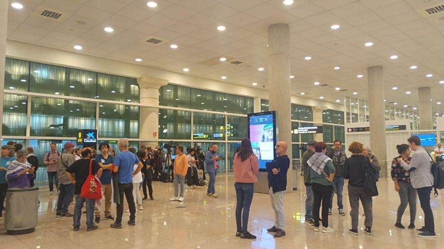 Personas esperando a los miembros de la flotilla en el aeropuerto de El Prat