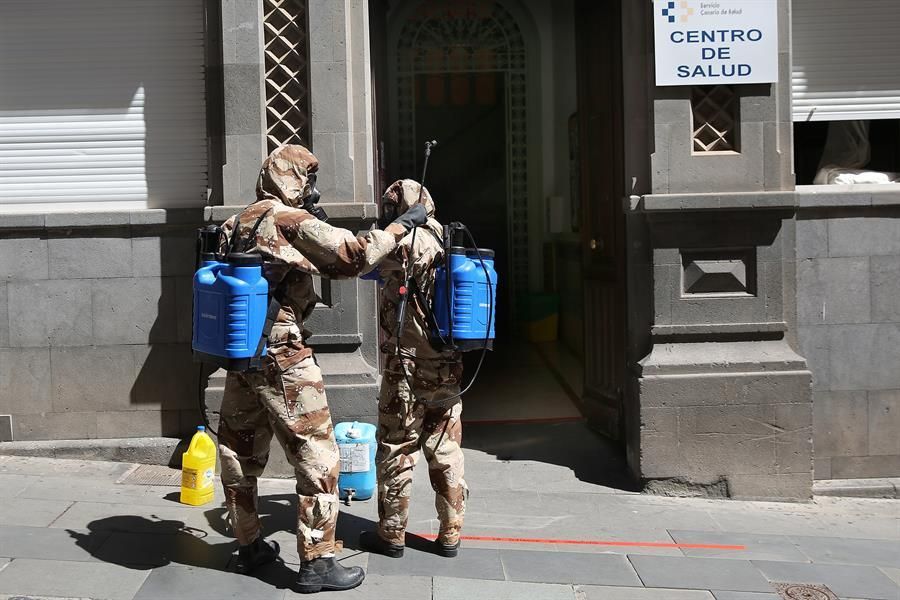 Efectivos del Ejército de Tierra, con trajes de protección, realizan labores de desinfección en el centro de salud de la zona centro de Santa Cruz