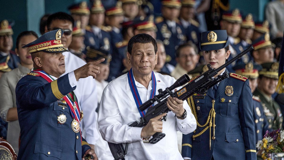 Rodrigo Duterte sostiene un rifle de francotirador Galil junto al entonces jefe de la Policía Nacional de Filipinas, Ronald dela Rosa, durante la ceremonia de cambio de mando en el campamento Crame en Manila, el 19 de abril de 2018.