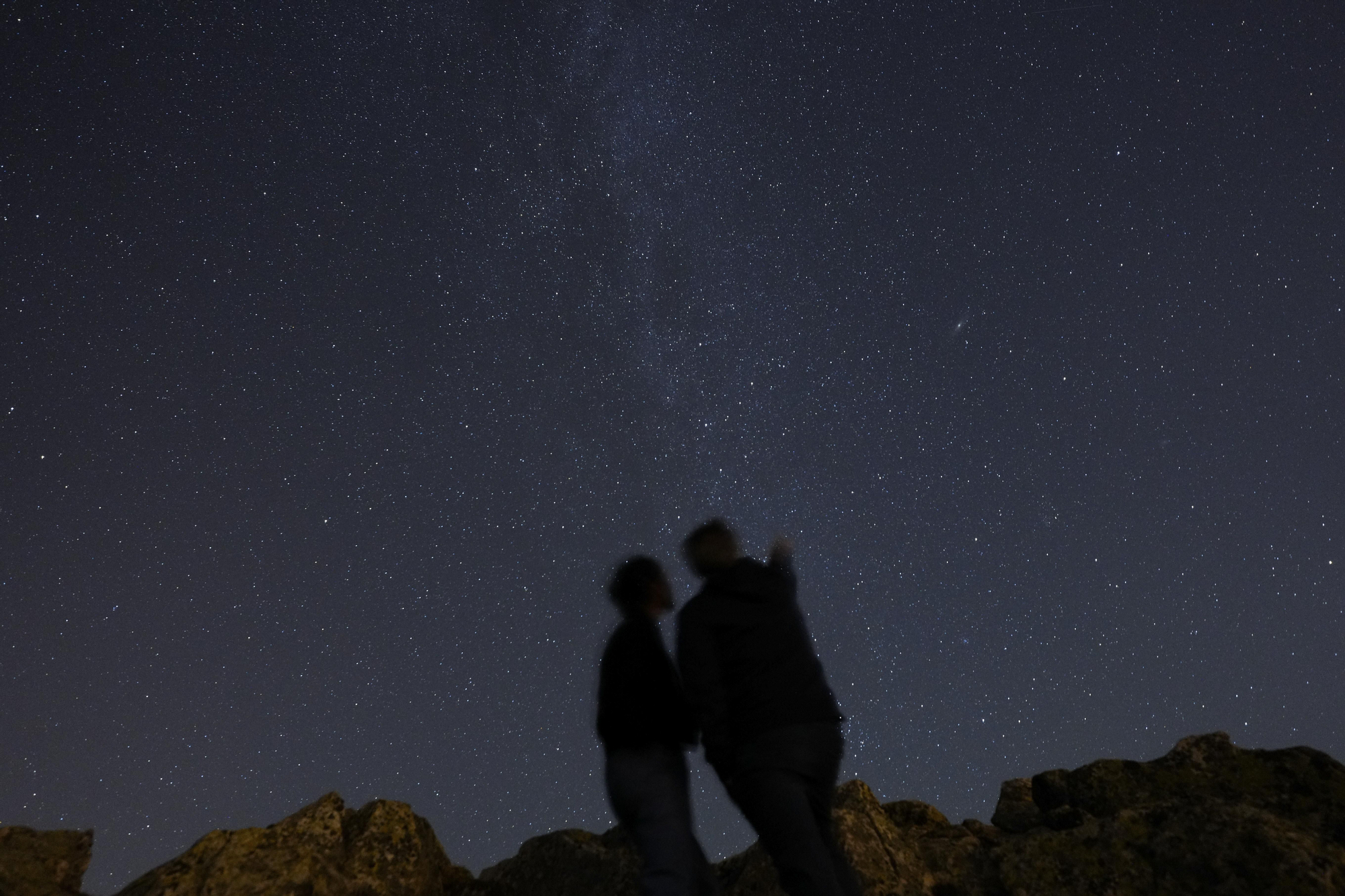 Dos personas observan el cielo para observar alguna estrella fugaz en la madrileña sierra de Guadarrama en la madrugada de este domingo. EFE/ Borja Sánchez-Trillo