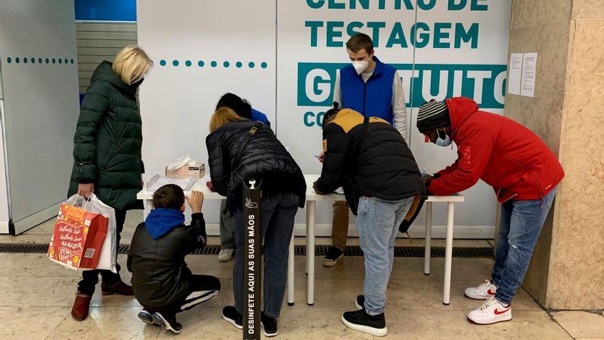 Varios pasajeros de la estación de metro de Alameda en Lisboa, Portugal, rellenan un formulario para someterse a un test de covid gratuito en uno de los nuevos puntos habilitados en la ciudad. EFE/ Brian Bujalance