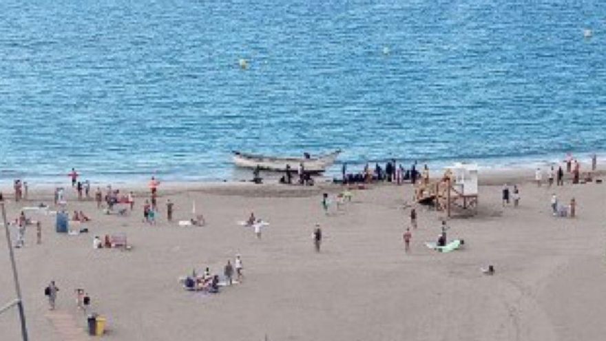 Migrantes en la playa de Las Vistas tras arribar con una patera