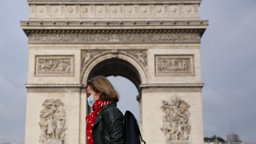 Una mujer con mascarilla ante el Arco del Triunfo de París.