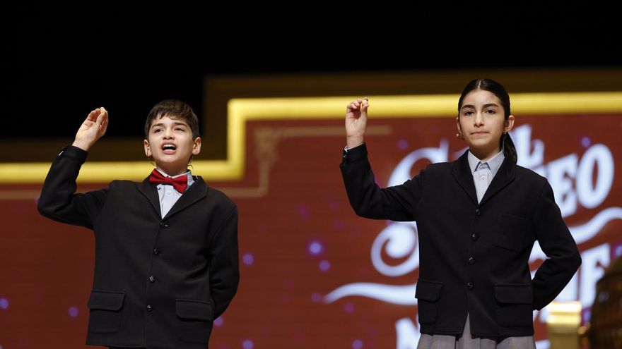 Los niños de la Residencia San Ildefonso del Ayuntamiento de Madrid Rosario Martínez y Matías Martínez cantan el segundo cuarto premio que ha recaído sobre el número 25.508 durante el Sorteo Extraordinario de Navidad celebrado este lunes en el Teatro Real.