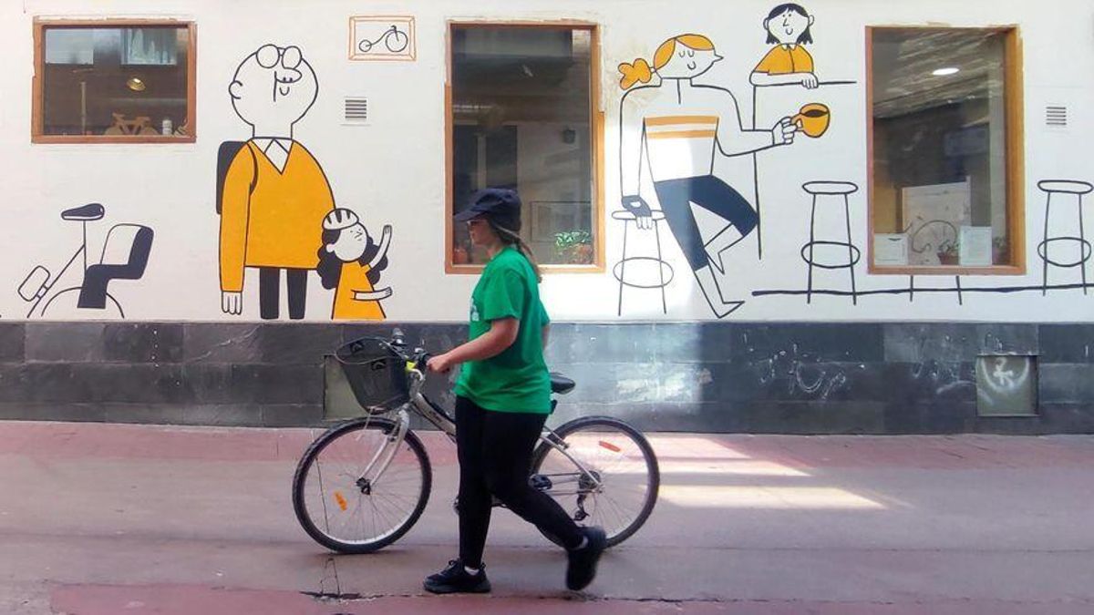 Una ciclista, a pie por Zaragoza.