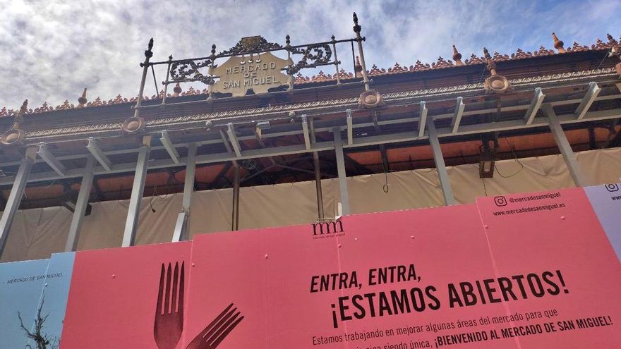 Una valla alrededor del Mercado de San Miguel ofrece un mensaje contradictorio durante su cierre.