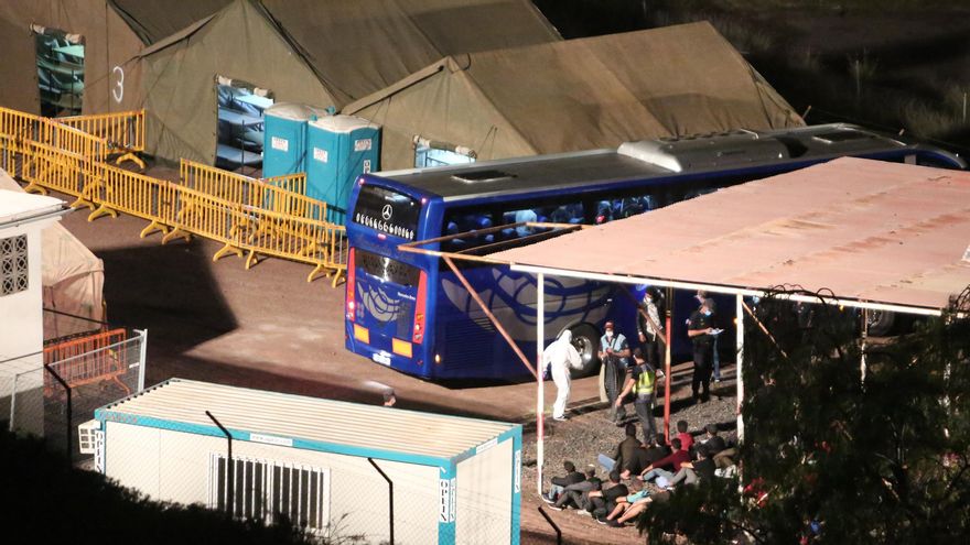 Los migrantes esperan a ser asignados a sus literas en el campamento de Barranco Seco.