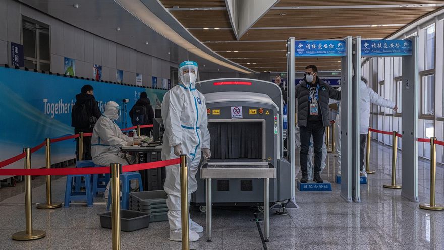 Personal con equipo protector comprueba a los pasajeros en una estación de tren después de su llegada en un tren olímpico especial a Zhangjiakou, dentro de la "burbuja olímpica" COVID-19 en China.