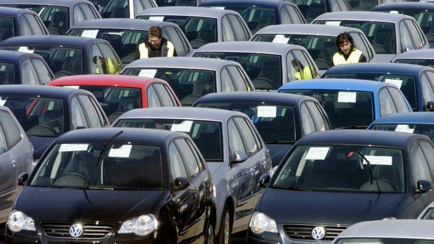 Dos personas supervisan el estado de los vehículos Volkswagen, en Pamplona.
