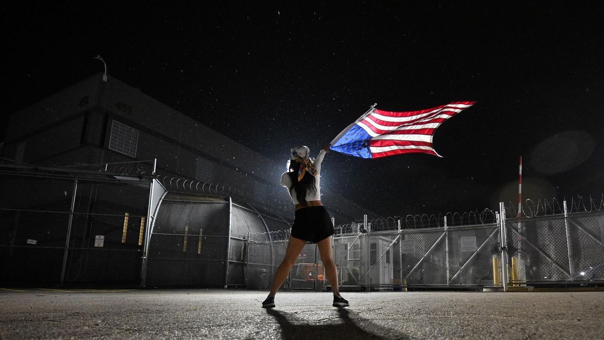 Una mujer protesta con una bandera de EEUU boca abajo delante de un centro de detención del ICE en Newark, New Jersey, el 5 de julio.