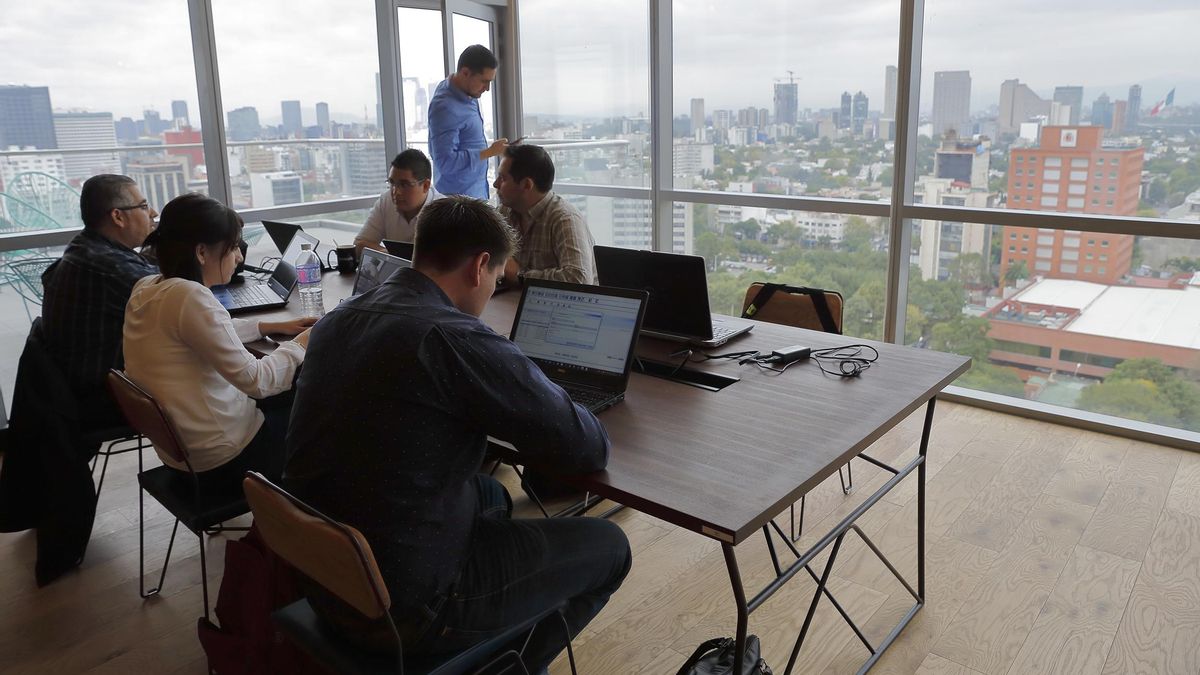 Fotografía de archivo de empleados trabajando en una oficina. 