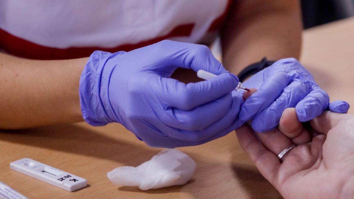 Un profesional sanitario realiza un test de coronavirus a una mujer, foto de archivo