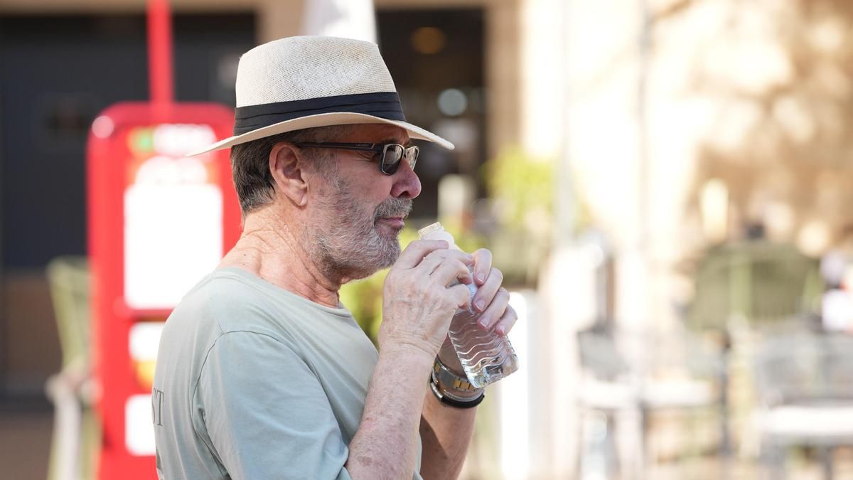 Un hombre se refresca en Córdoba.