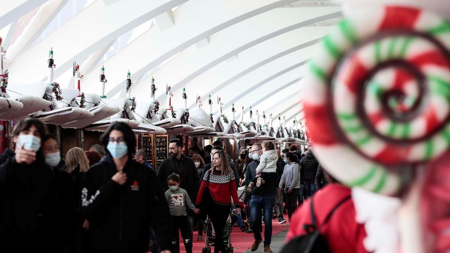 Decenas de personas pasean por un mercadillo navideño situado en la Ciudad de las Artes y las Ciencias de Valencia, este domingo.