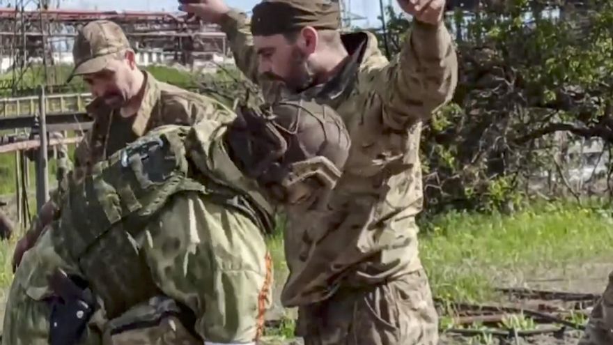 Imagen tomada de un video facilitado por el servicio de prensa del Ministerio de Defensa ruso que muestra a un militar ruso cacheando a militares ucranianos evacuados de la planta siderúrgica de Azovstal en Mariupol, Ucrania. EFE/EPA/RUSSIAN DEFENCE MINISTRY PRESS SERVICE HANDOUT