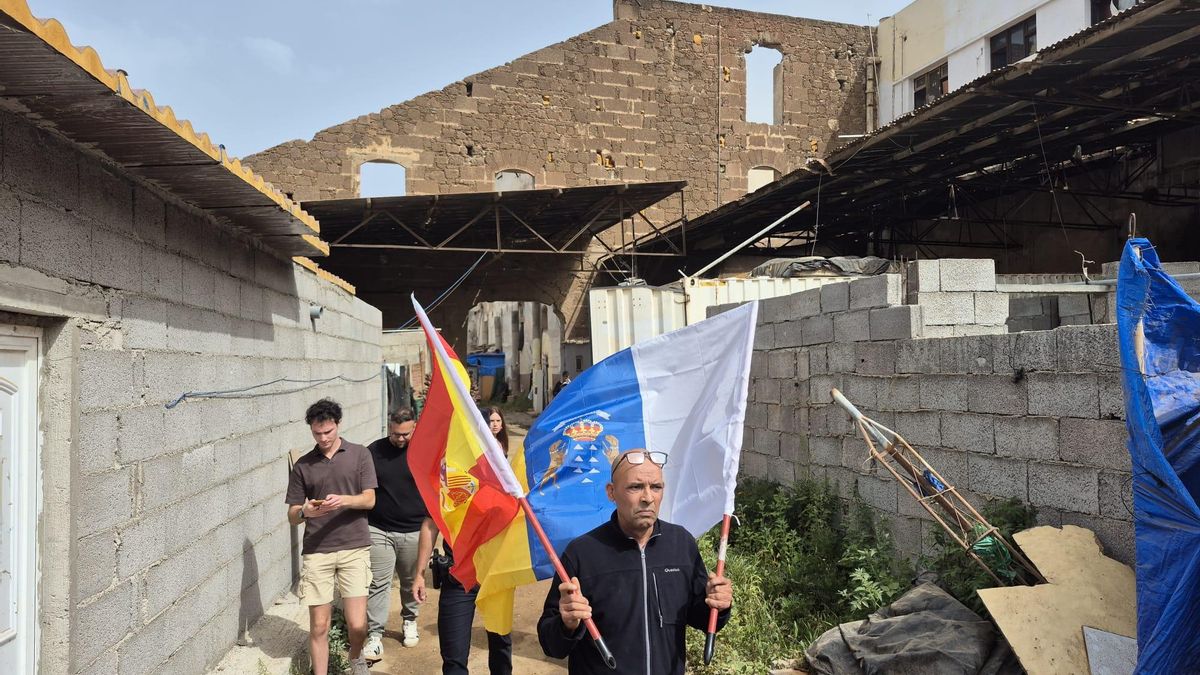 Uno de los vecinos desalojados porta las banderas canaria y española.