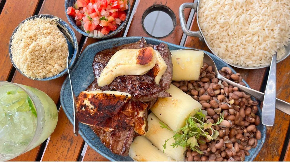Plato de carne brasileña con queso, yuca, frijoles, arroz y farofa