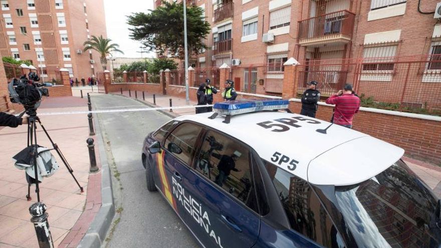 Agentes de la policía nacional y local en la entrada del edificio donde murió la víctima.