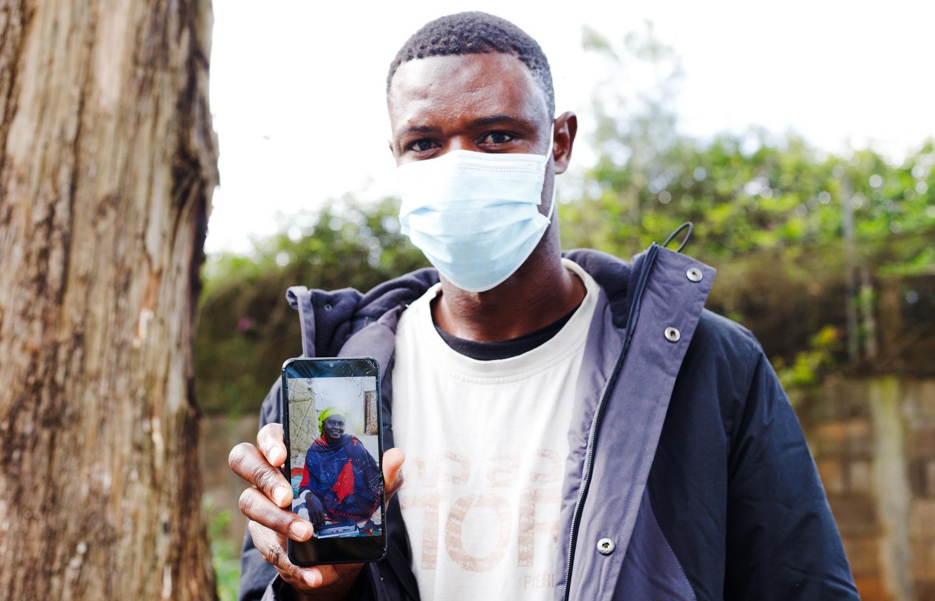 Baba, uno de los migrantes acogidos en el campamento de Las Raíces, muestra la foto de su madre, Binta.