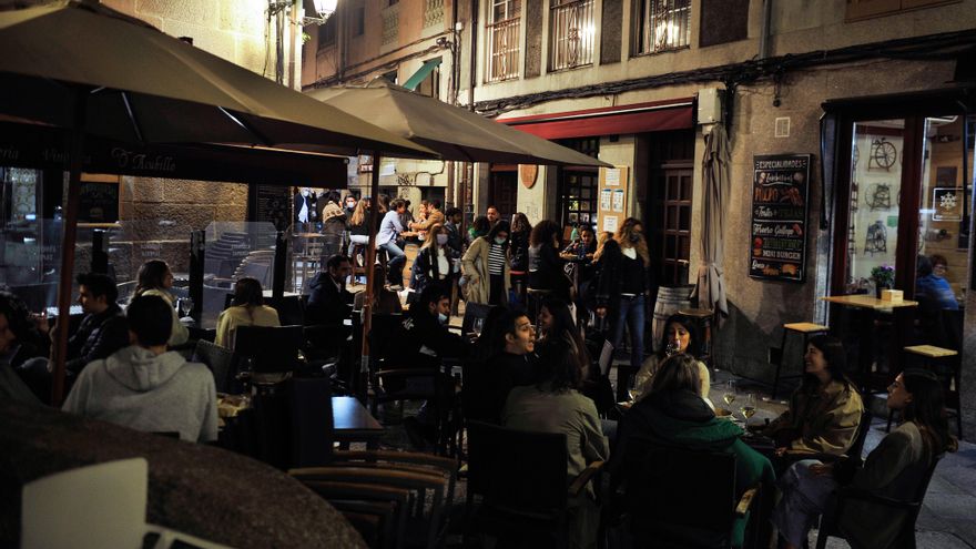Varias personas en la terraza de un bar.