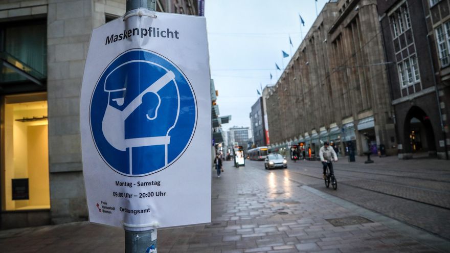 Un cartel que indica la obligatoriedad del uso de mascarillas cuelga de un poste en el centro de la ciudad de Bremen, en el norte de Alemania. EFE/ Focke Strangmann