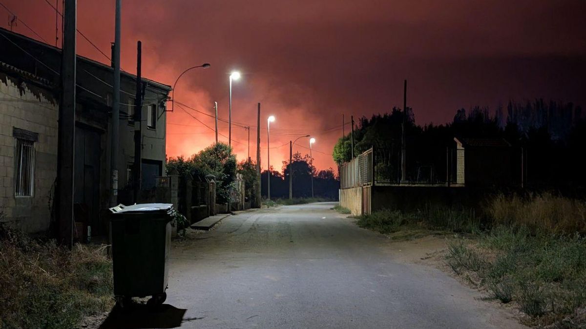 La Nora del Río con llamas del incendio de fondo