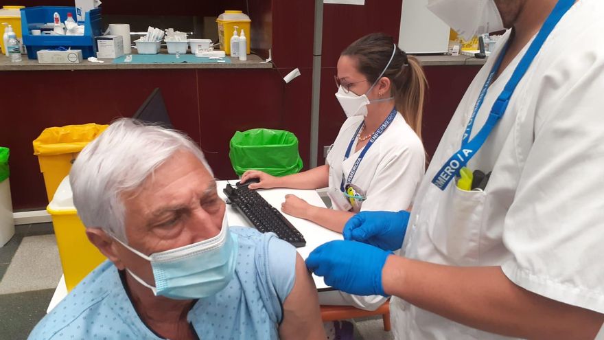 Un sanitario administra una dosis de la vacuna contra la COVID-19 a un hombre en Canarias