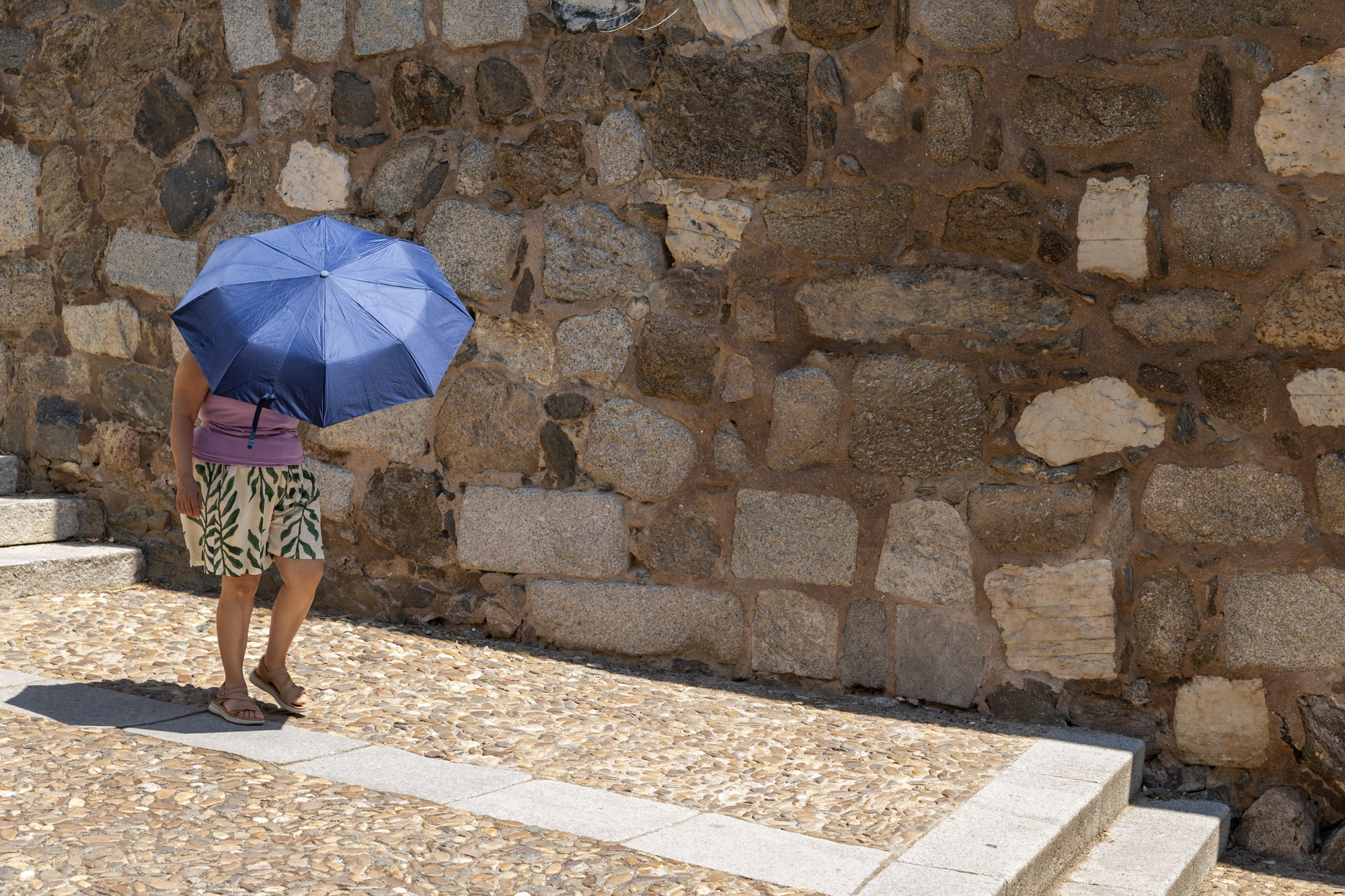 Una mujer se protege del calor con un paraguas durante este lunes en Valencia