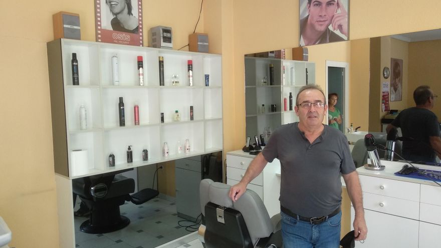 Andrés Ramírez posa en su peluquería, también afectada por las obras.