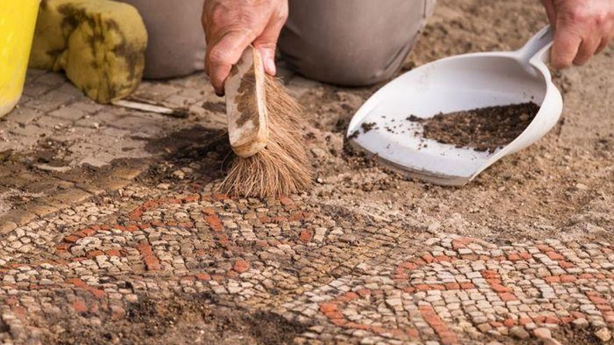 Un miembro del equipo de los Servicios Arqueológicos de la Universidad de Leicester durante las excavaciones de un gran mosaico en Rutland, Reino Unido