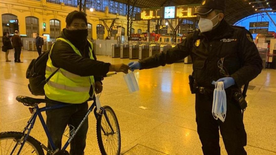 Un policia reparte mascarillas en la Estación del Norte de València