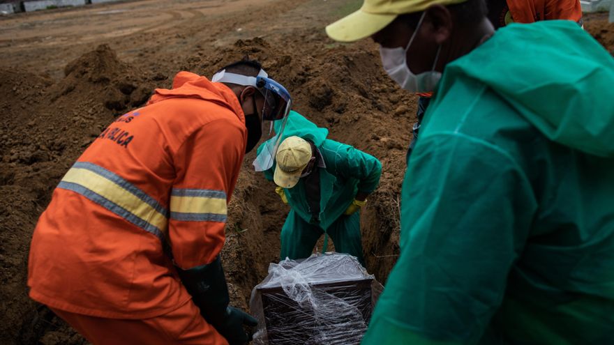 Trabajadores entierran el ataúd con el cuerpo de un fallecido por covid-19 en el área destinada a las víctimas de la pandemia en el cementerio público Nossa Senhora Aparecida, en Manaos, Amazonas (Brasil). EFE/Raphael Alves/Archivo