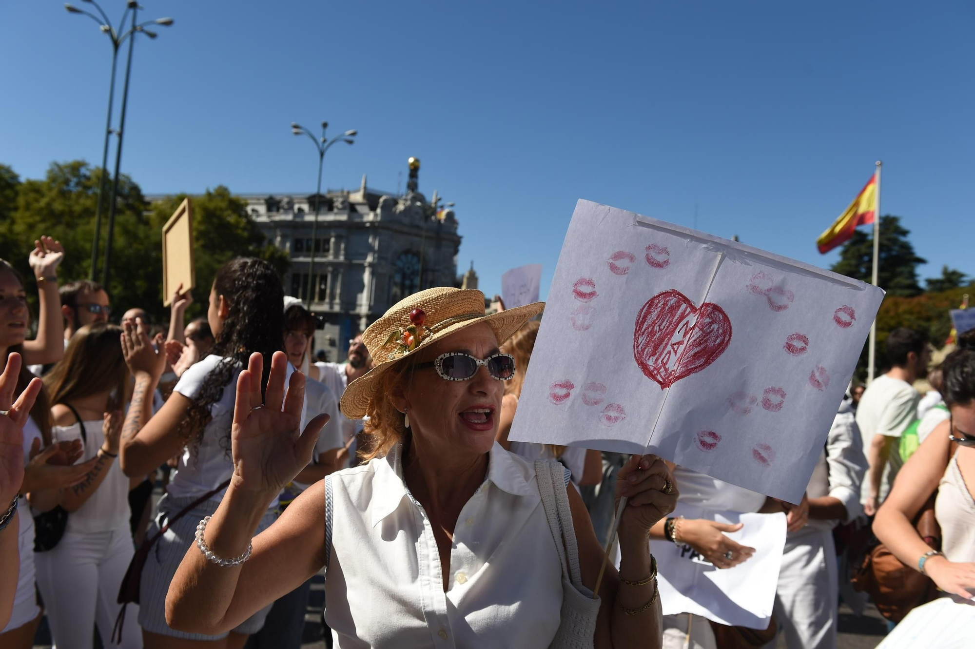 Una mujer porta una pancarta con símbolos a favor del diálogo