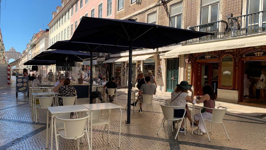 os habitantes de las principales ciudades de Portugal, tales como Lisboa, Oporto, Braga o Faro tendrán prohibido circular por la calle a partir de hoy entre las 23 y las 05 horas, una medida aplicada por el Gobierno para frenar el avance de un virus dominado por la variante delta de la covid. En la imagen, lisboetas en una terraza de la Rua Augusta.