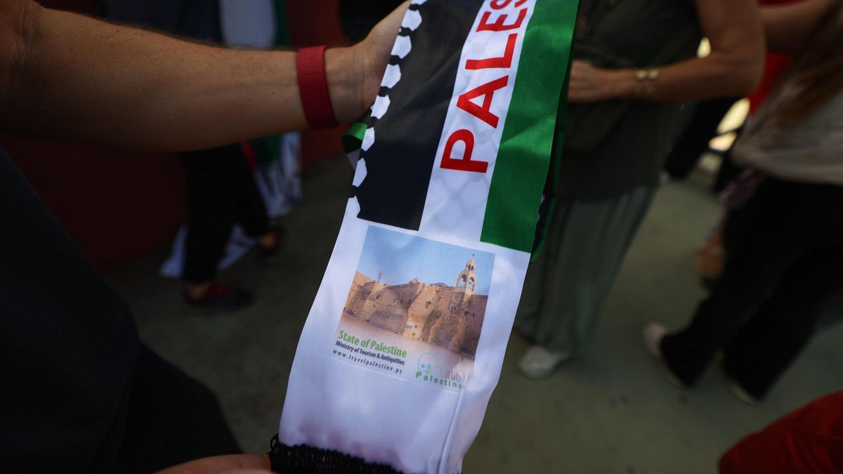 Un docent mostra una bufanda amb la bandera palestina en la lectura del manifest