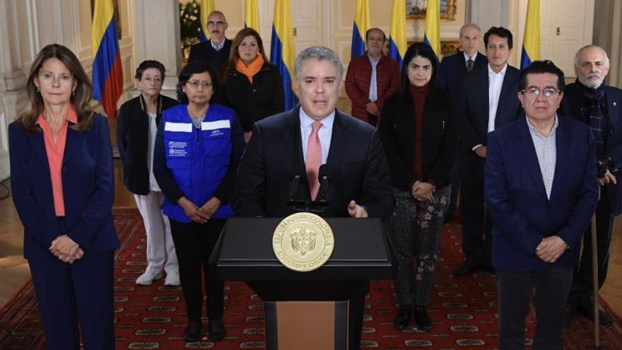 Fotografía cedida por la presidencia de Colombia del mandatario colombiano, Iván Duque (c), junto a la vicepresidente de Colombia, Marta Lucia Ramírez (i), y el ministro de Salud y Protección Social, Dr. Fernando Ruiz Gómez, mientras ofrece un mensaje este viernes, en Bogotá (Colombia).