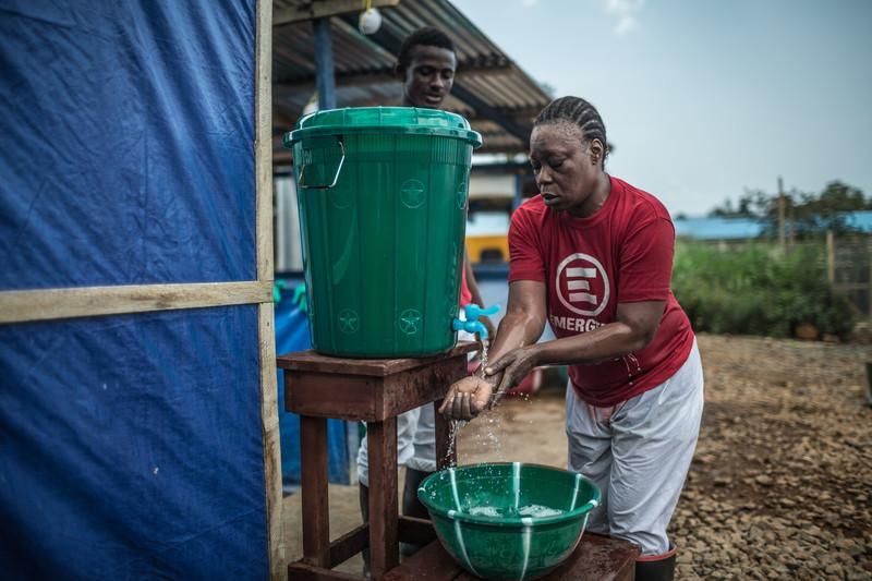 Limpiarse correctamente es fundamental en los centros. Oxfam Intermón proporciona cubos y agua con cloro para que las personas que trabajan directamente con los afectados por el ébola puedan lavarse adecuadamente y reducir el riesgo de contagio. Los trabajadores llevan dos pares de guantes que deben desinfectarse tantas veces como se pueda. Fotografía: Pablo Tosco/ Oxfam Intermón