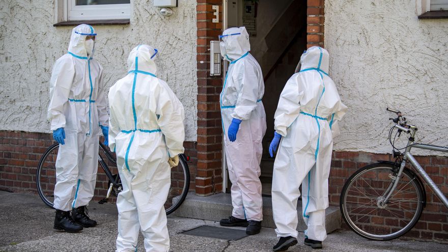 Voluntarios de Cruz Roja entran en un edificio de apartamentos para hacer pruebas de coronavirus en Alemania.
